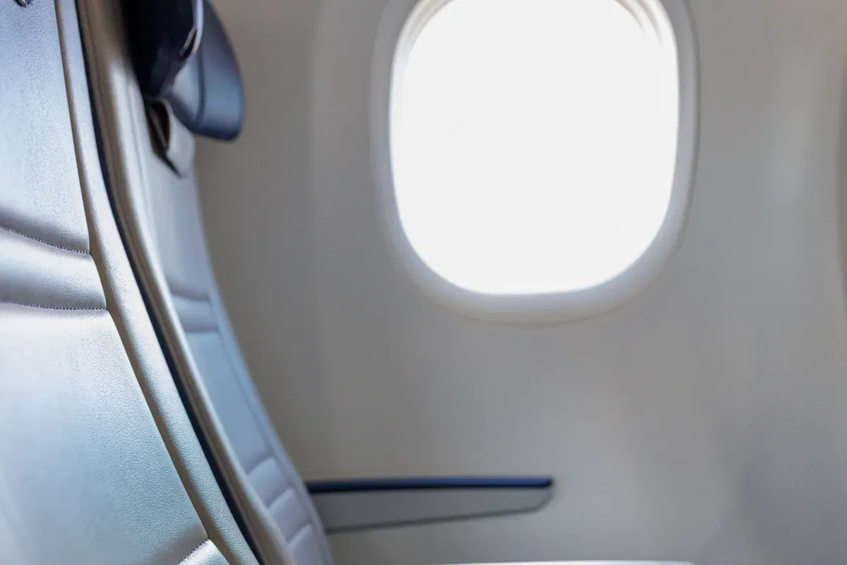Ein Fensterplatz im Flugzeug, durch den Tageslicht in die Kabine fällt
