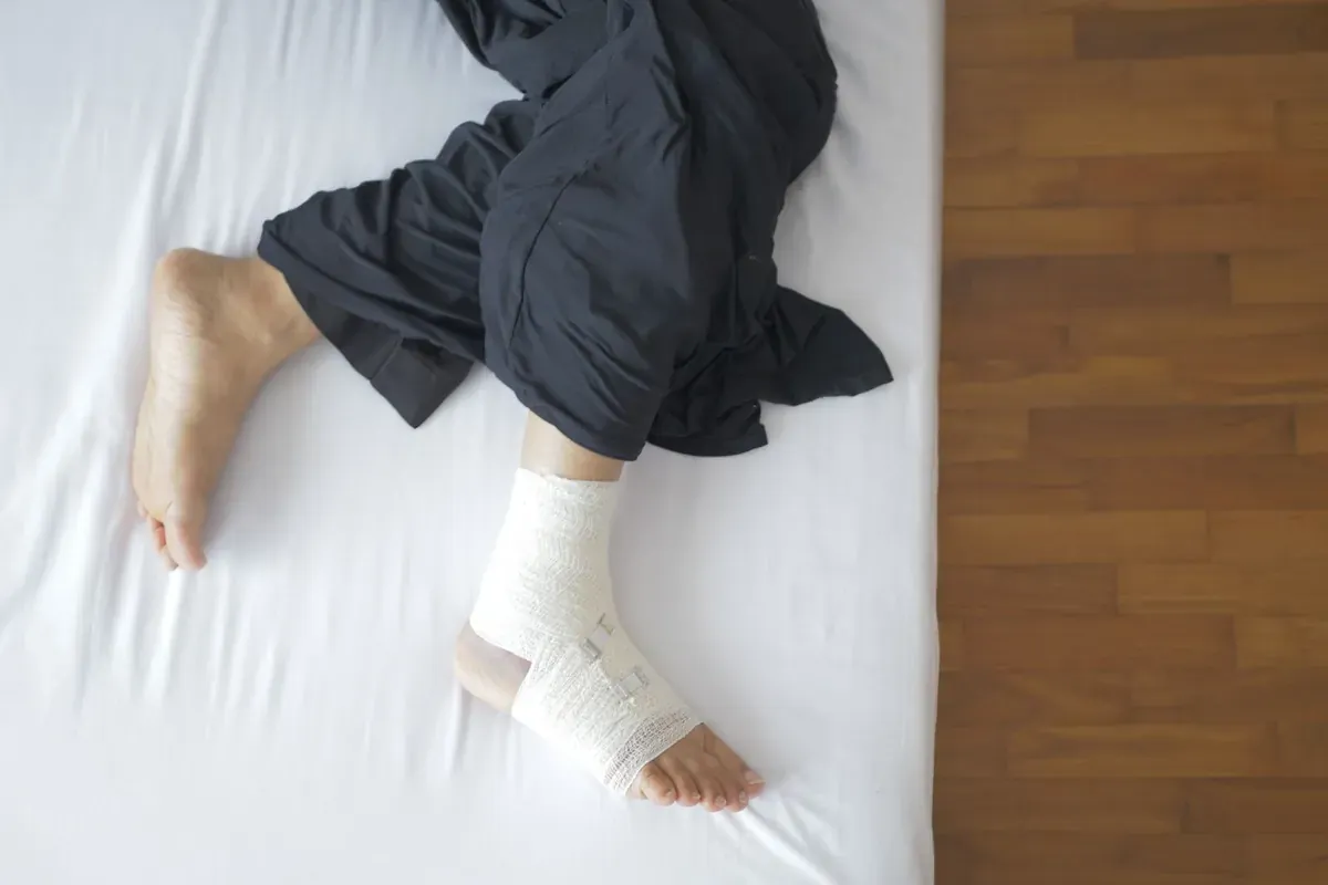 Ein bandagierter Fuß, der auf einem Bett ruht