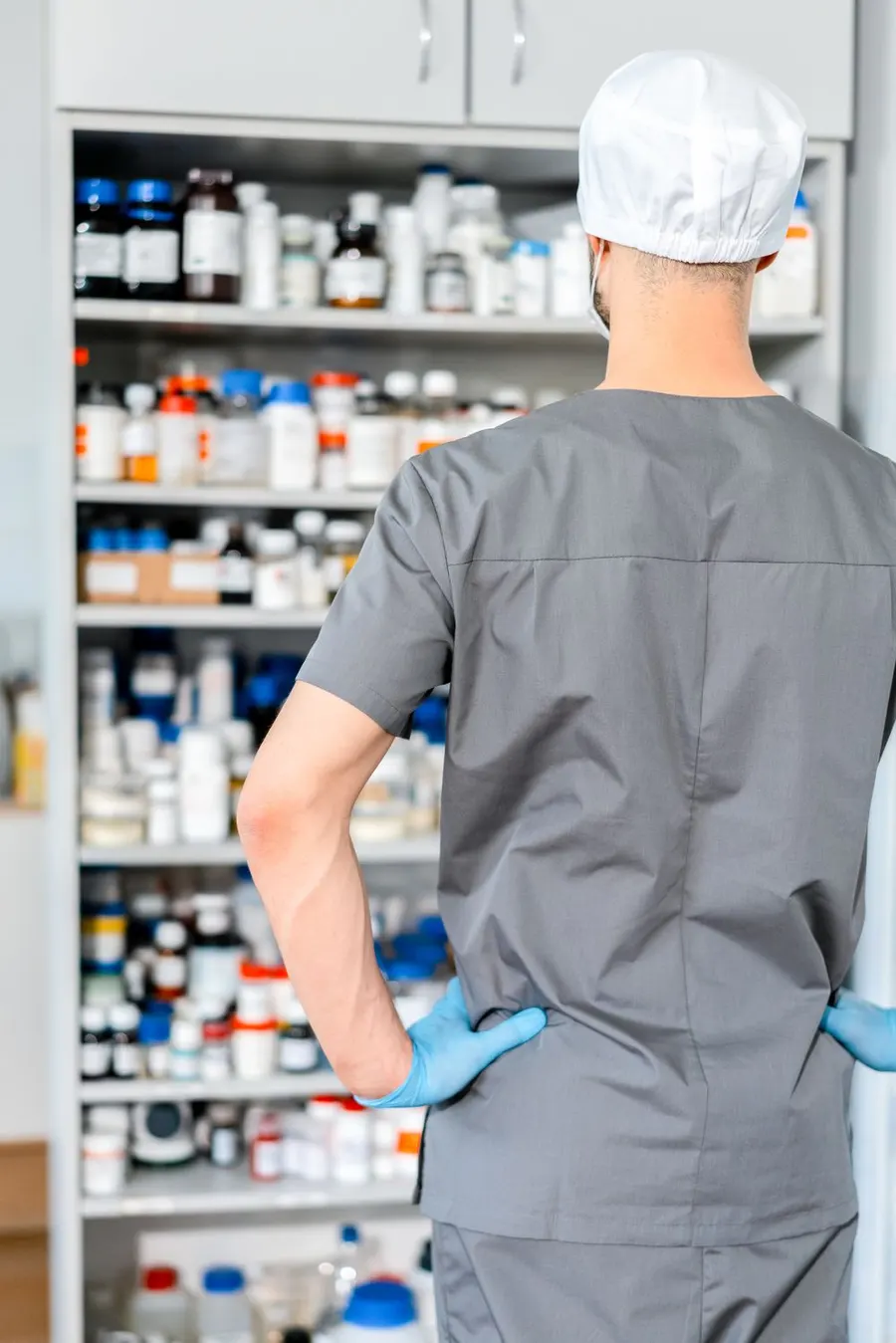 Ein Apotheker bereitet vor den Regalen Medikamente vor