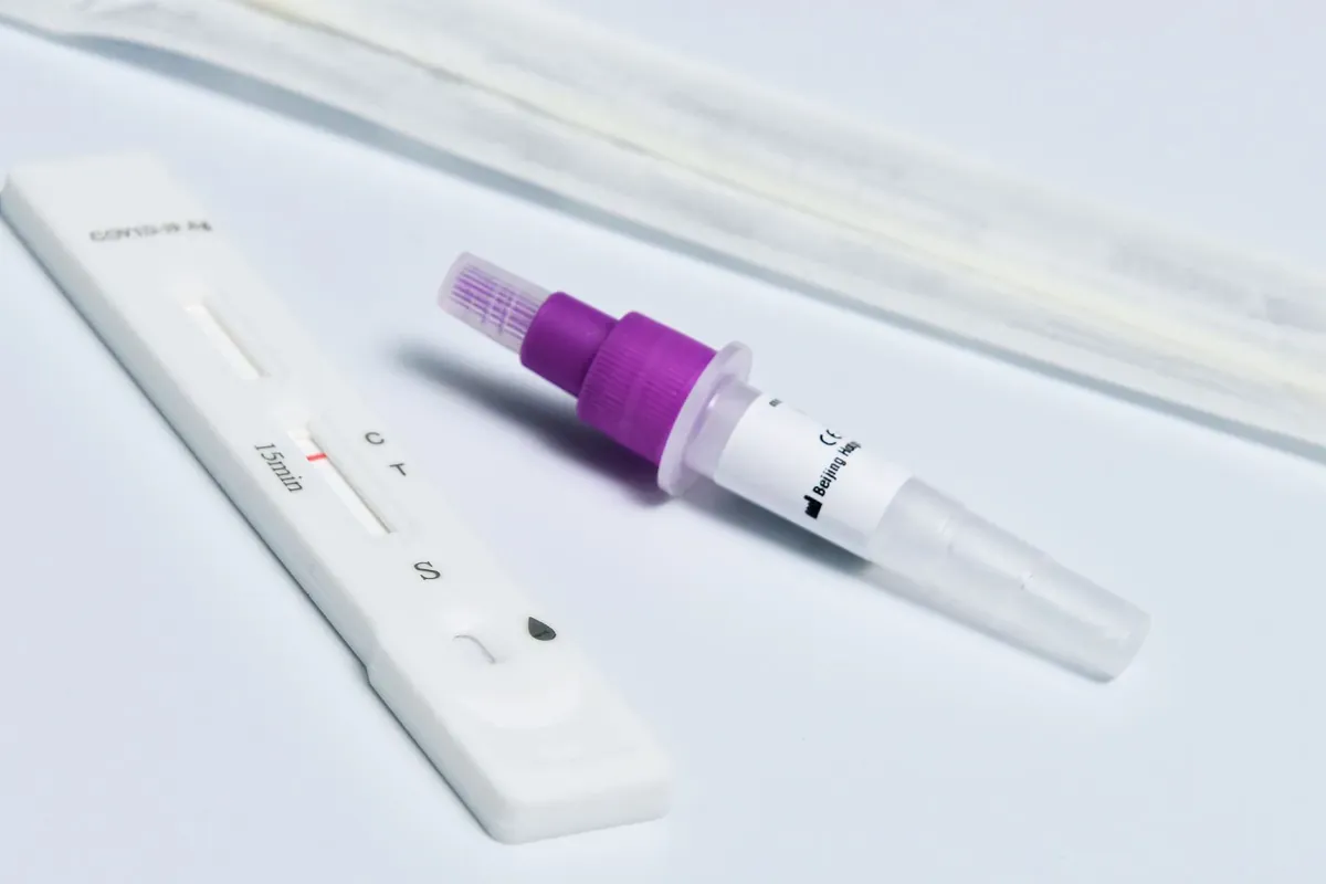 Eine Antigen-Schnelltestkassette und ein Abstrichtupfer auf weißer Fläche