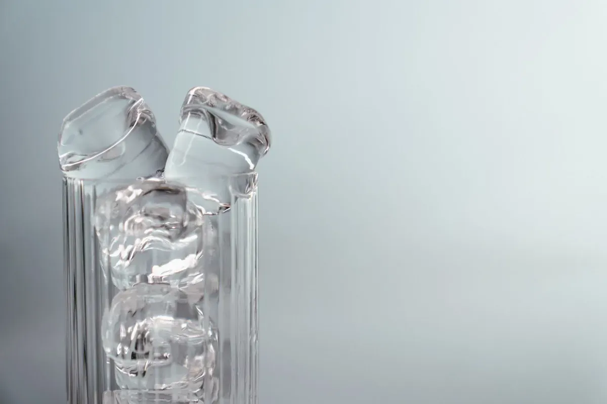 Glasflaschen mit Wasser vor hellem Hintergrund