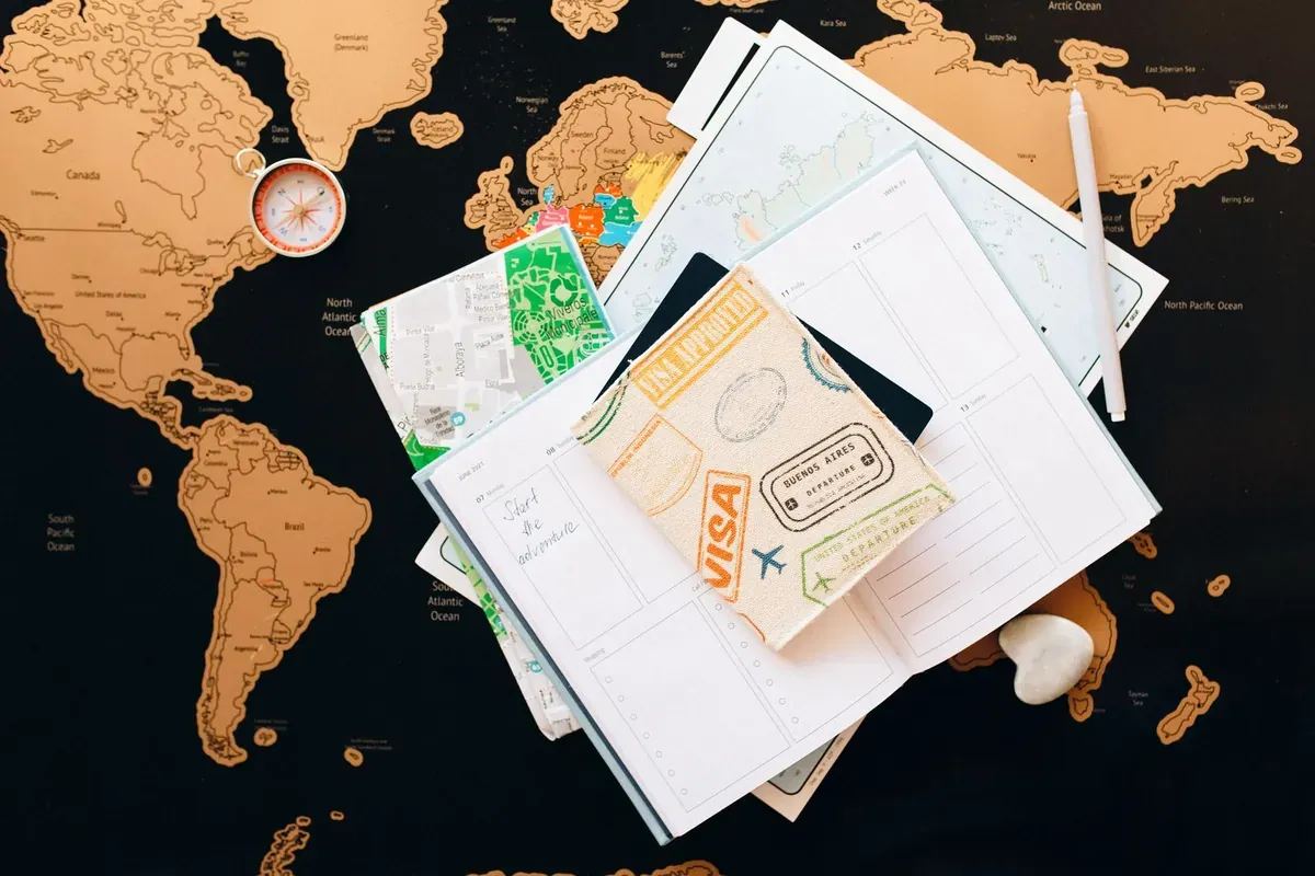 Reiseunterlagen und ein Reisepass, ausgebreitet auf einer Landkarte